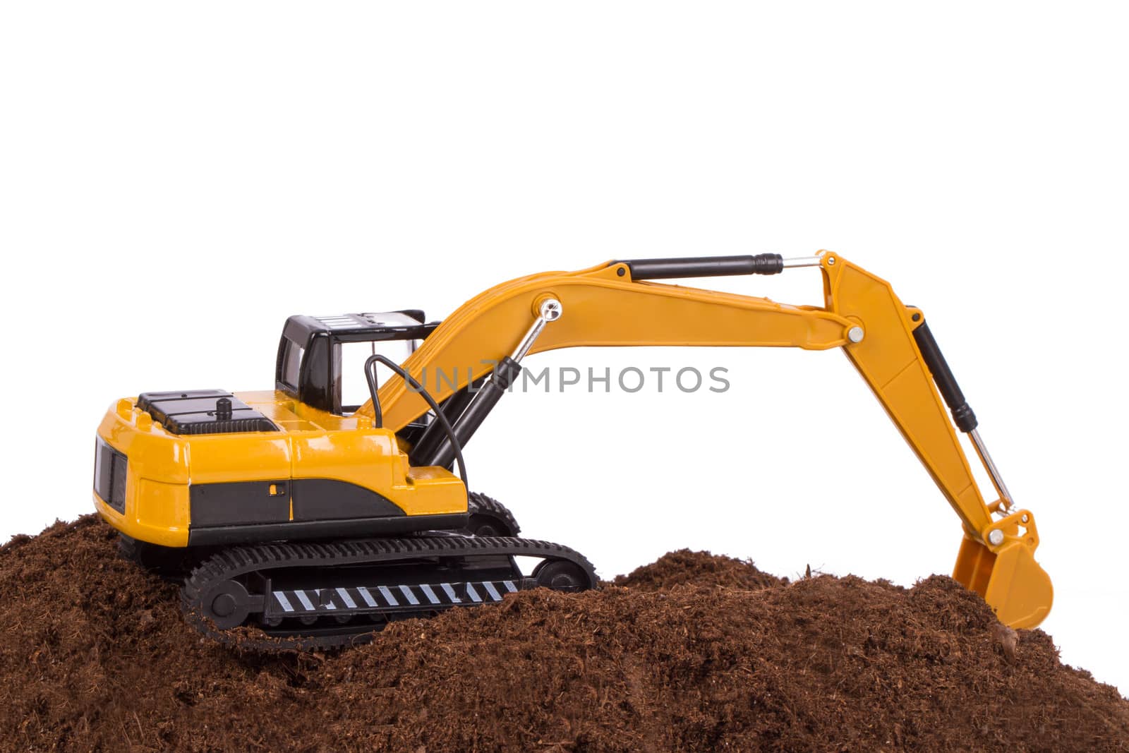 Construction machine, excavator on pile of soil digging a trench, isolated on white background.