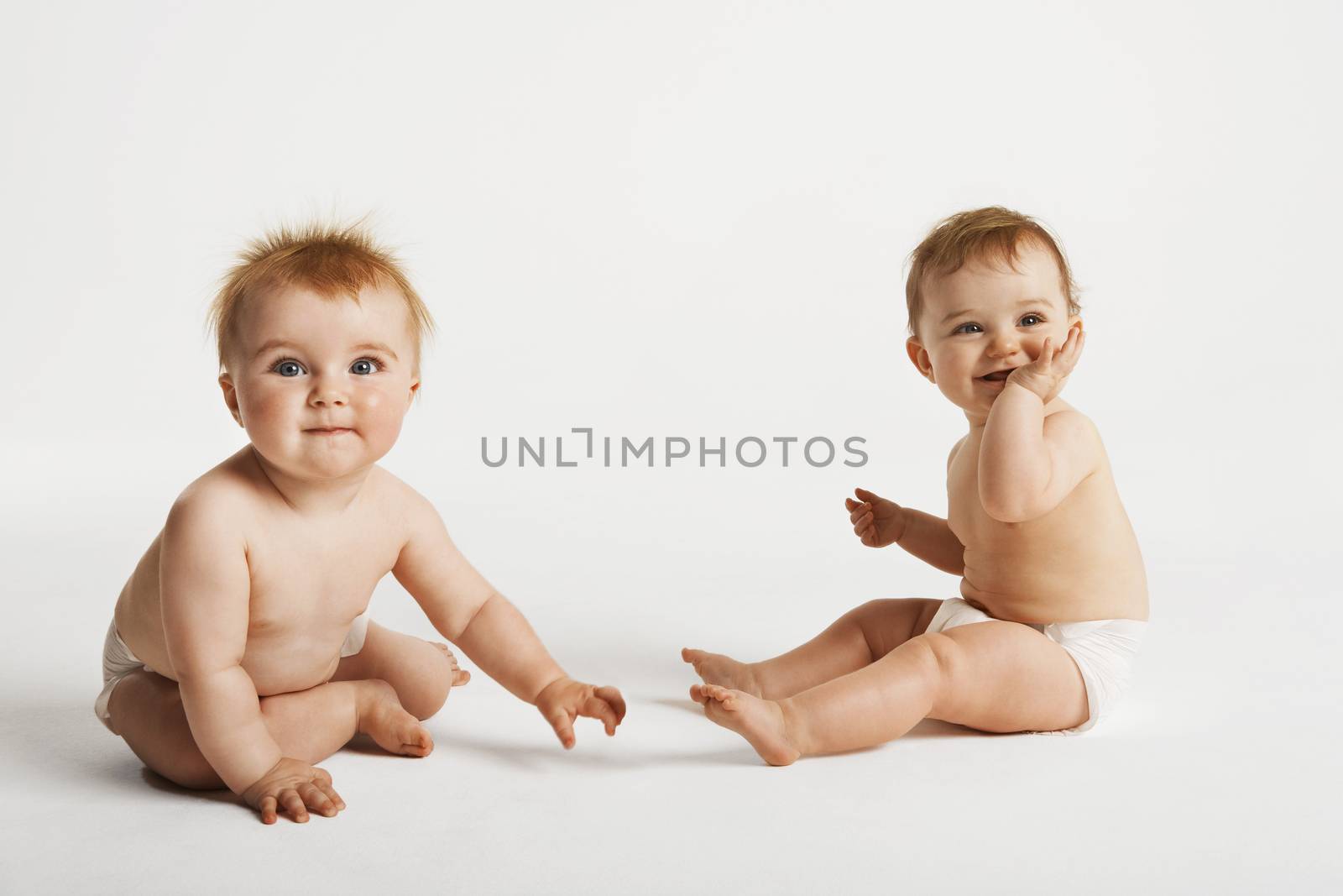 Full length of cute babies sitting isolated on white background by moodboard