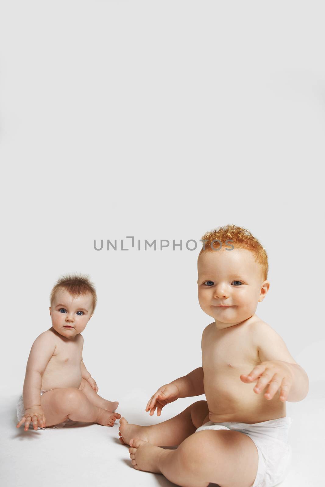 Portrait of cute babies sitting isolated on white background by moodboard