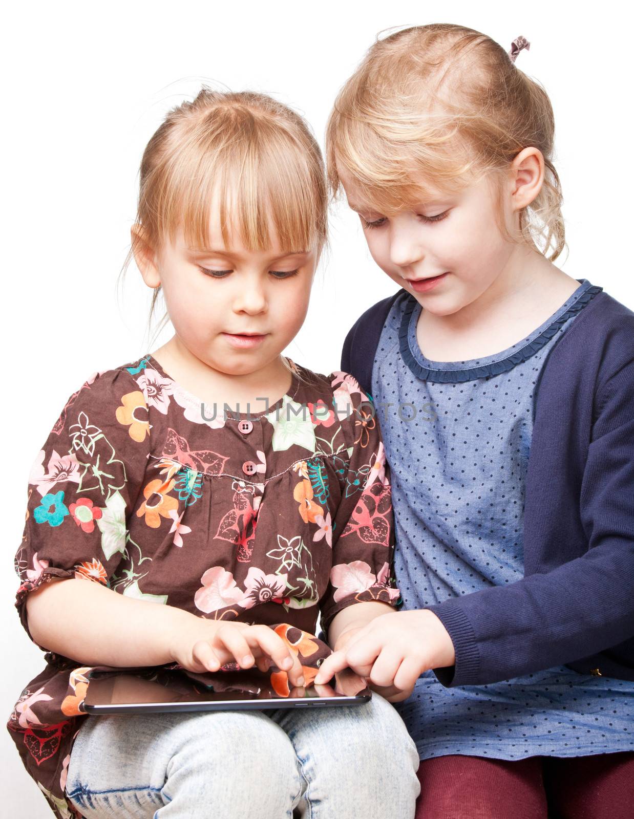 Girls playing with a tablet computer by naumoid
