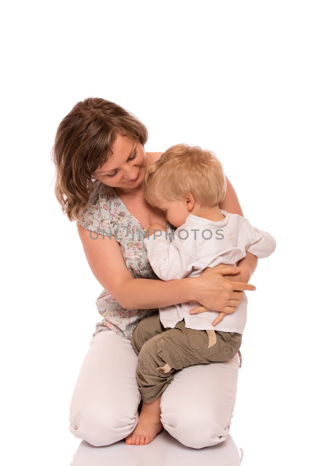 Young boy sitting on mother lap. Isolated on white background