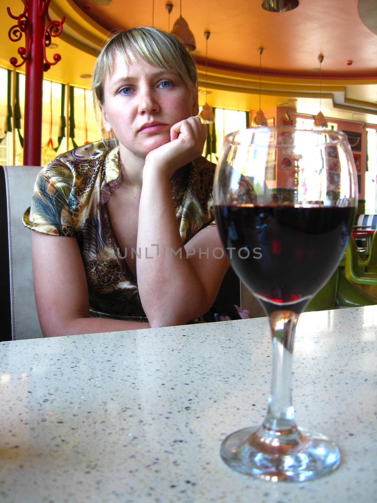 glass of red wine on the table and a lonely girl by alexmak