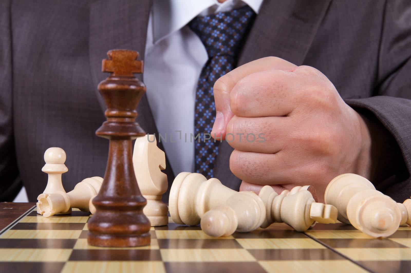 Businessman hits his punch to chess board, defeated concept.