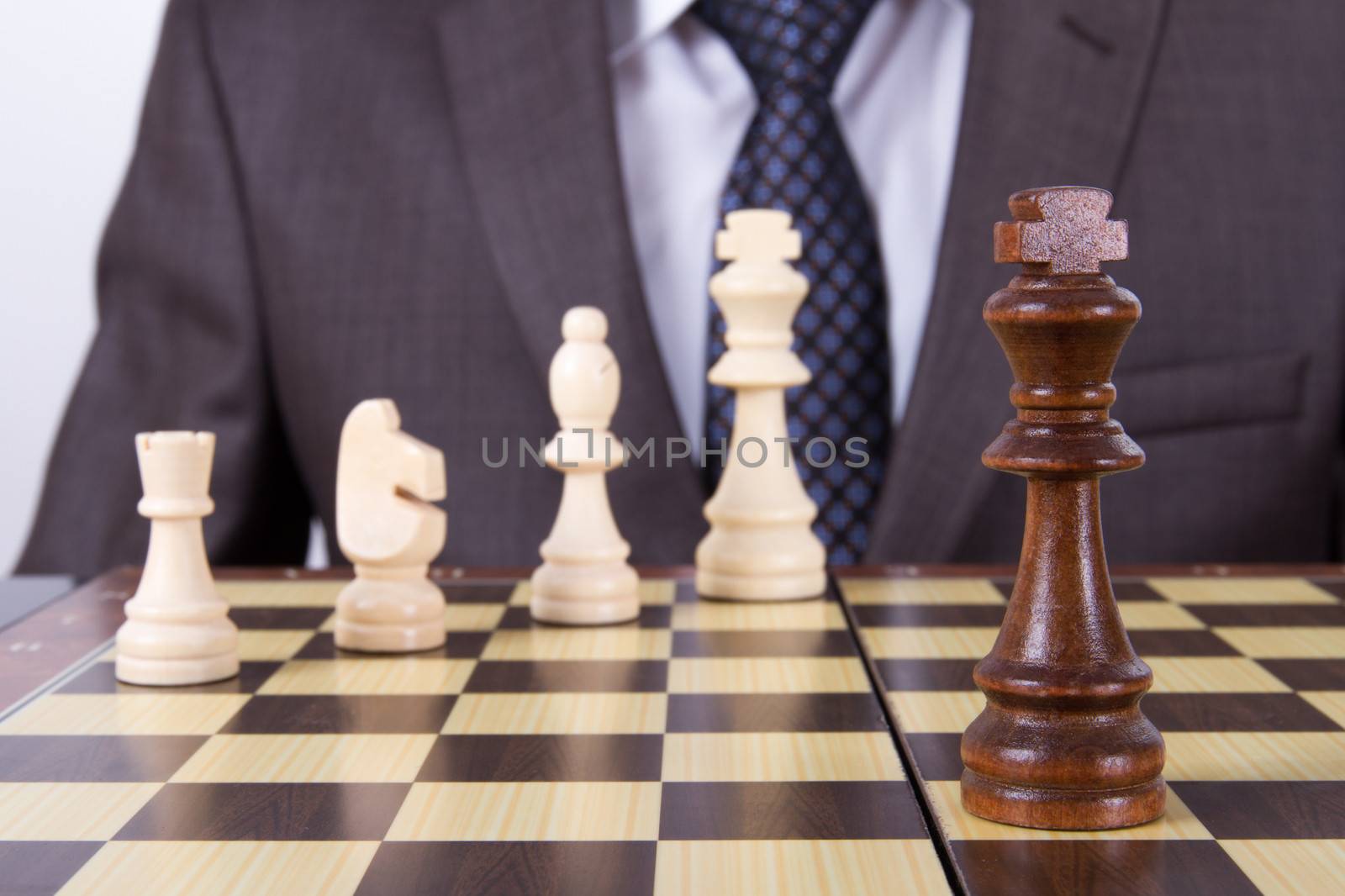 Businessman playing chess game on board.