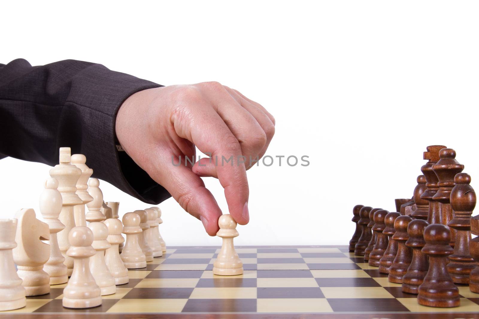 Businessman playing chess and holding pawn, isolated on white background.