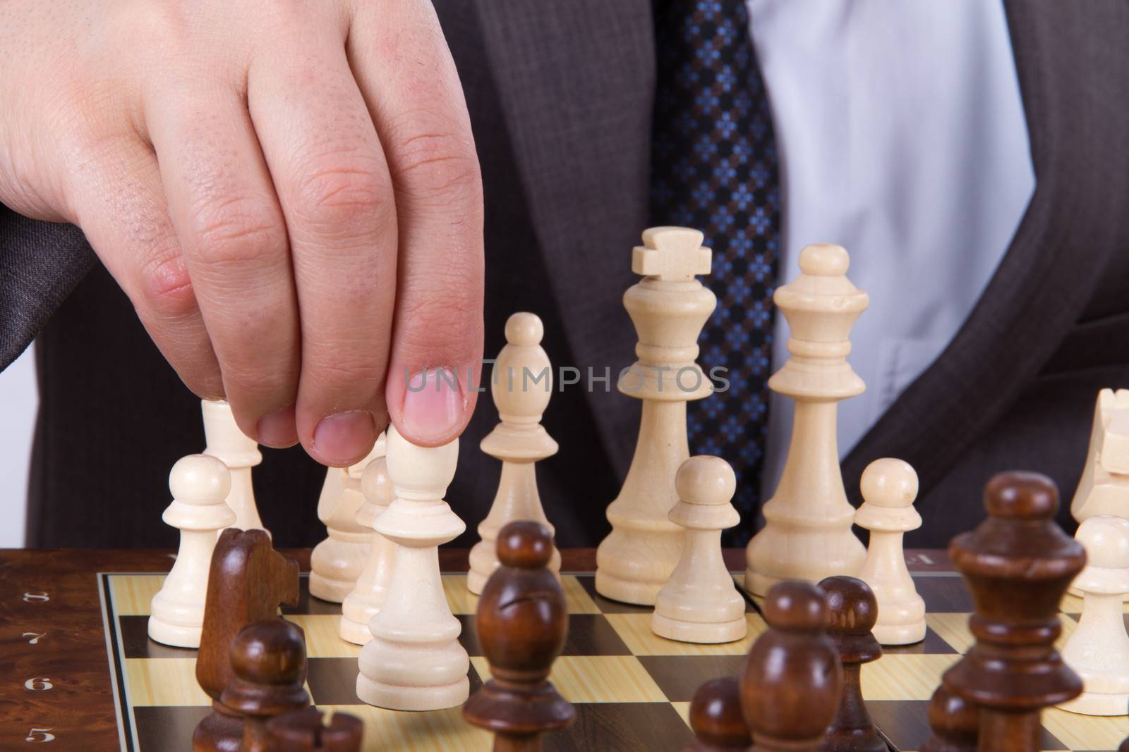 Businessman holding and moving bishop.