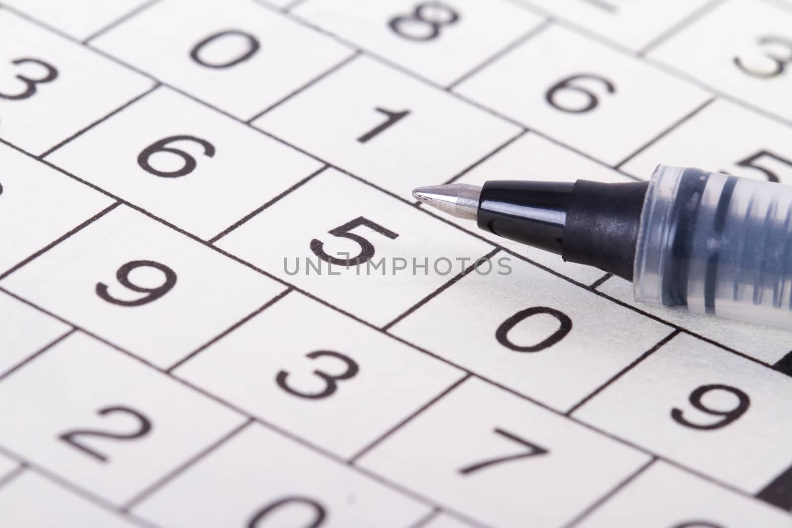 Close up of numbers crossword puzzle with black pen.