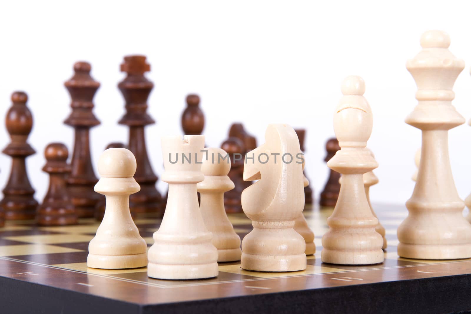 Chess board with chess pieces in a row, isolated on white background.