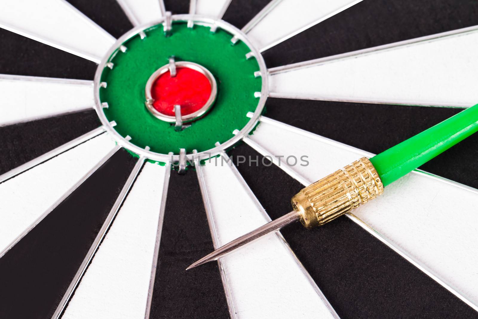 Green, plastic arrow on dart board.