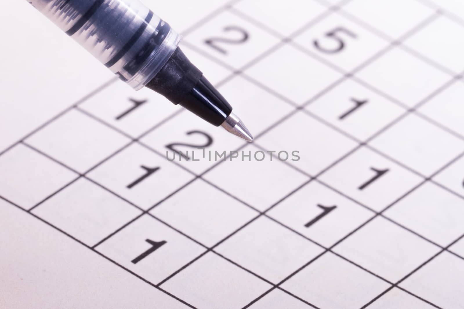 Close up of numbers crossword puzzle with black pen.