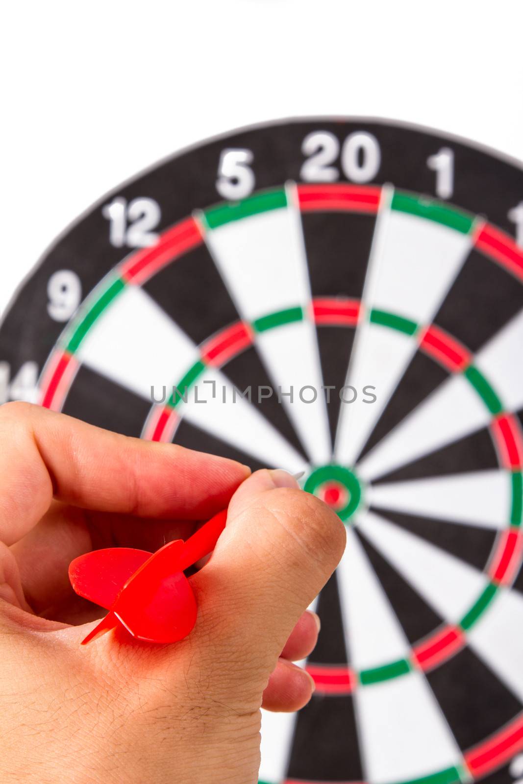 Hand holding plastic, red arrow and throwing to dart board, isolated on white background.