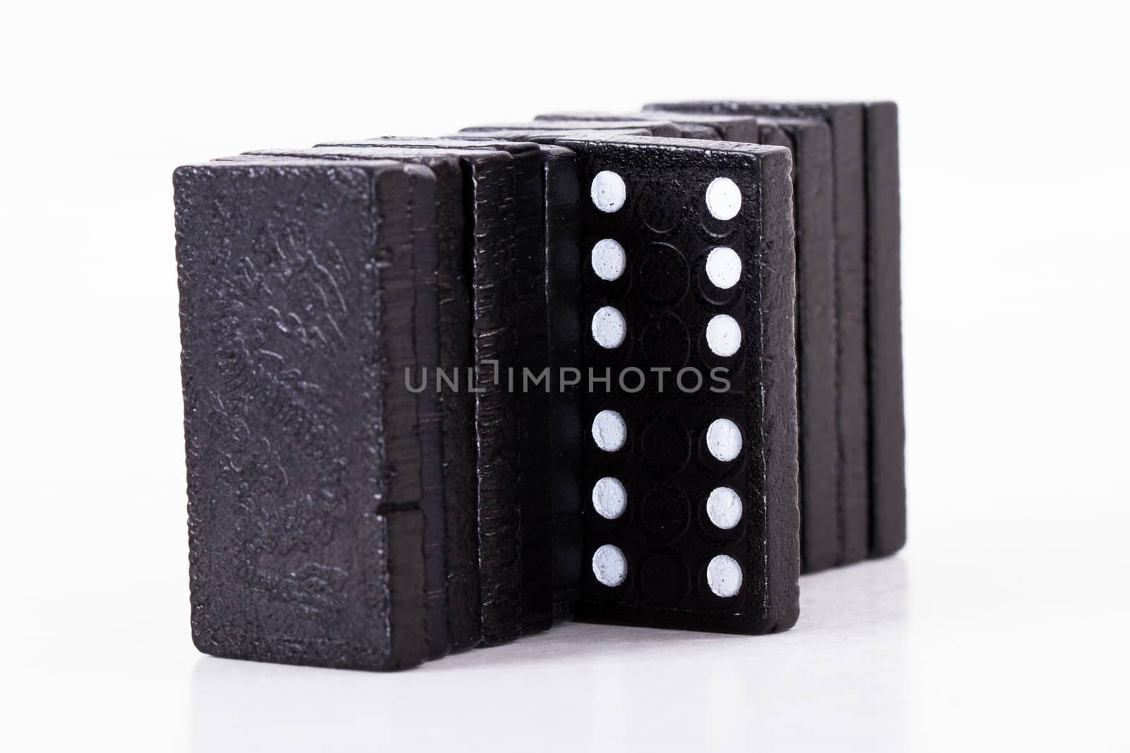 Leadership concept, domino standing out from the crowd, isolated on white background.