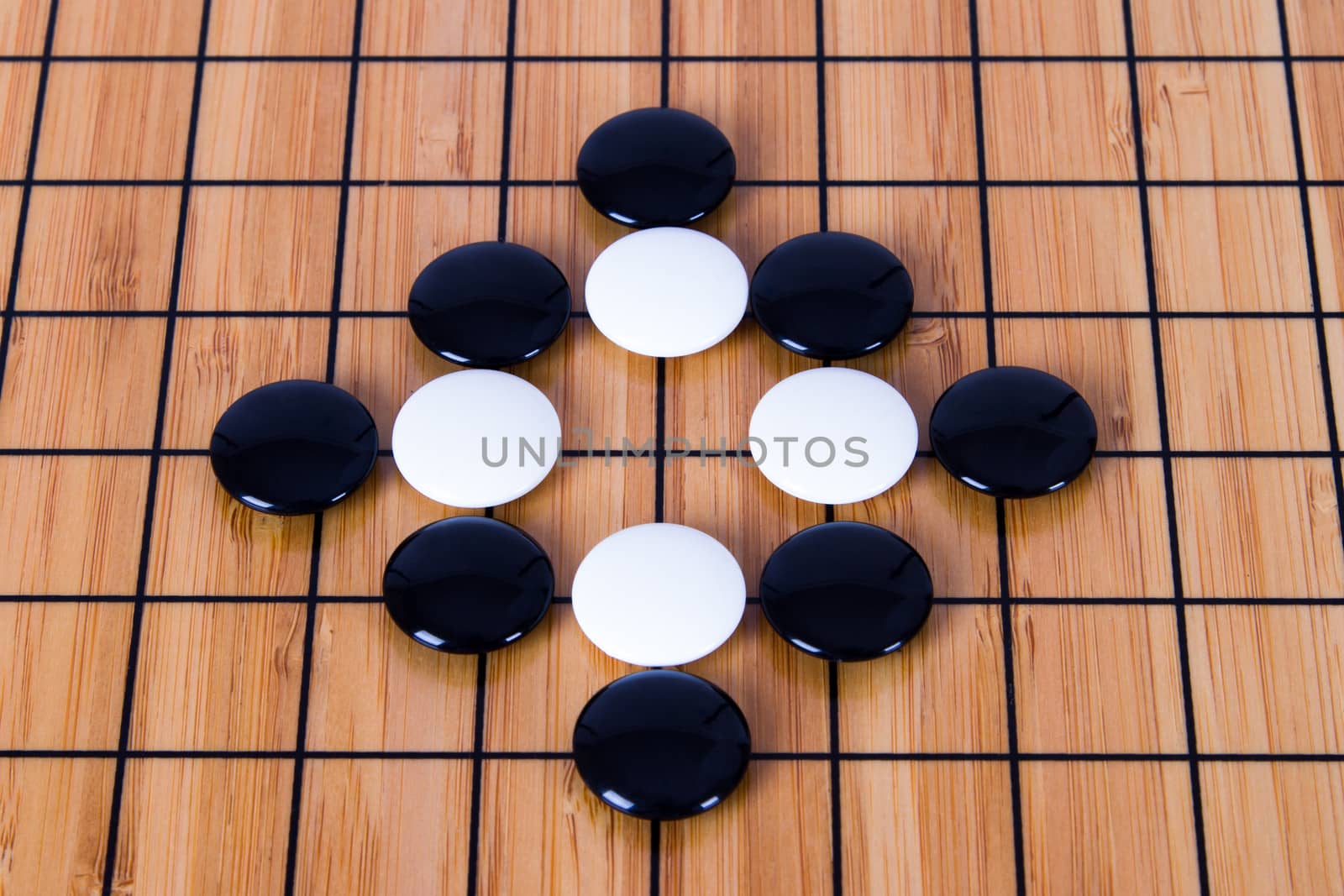 Close up view of black and white pieces on Chinese go game board.