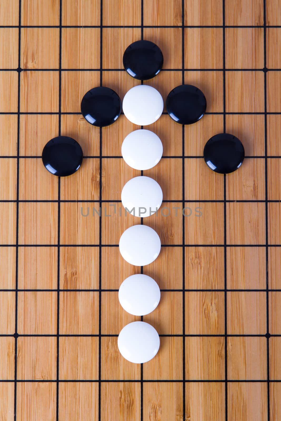Top view of black and white Chinese go game pieces, up direction arrow shape.