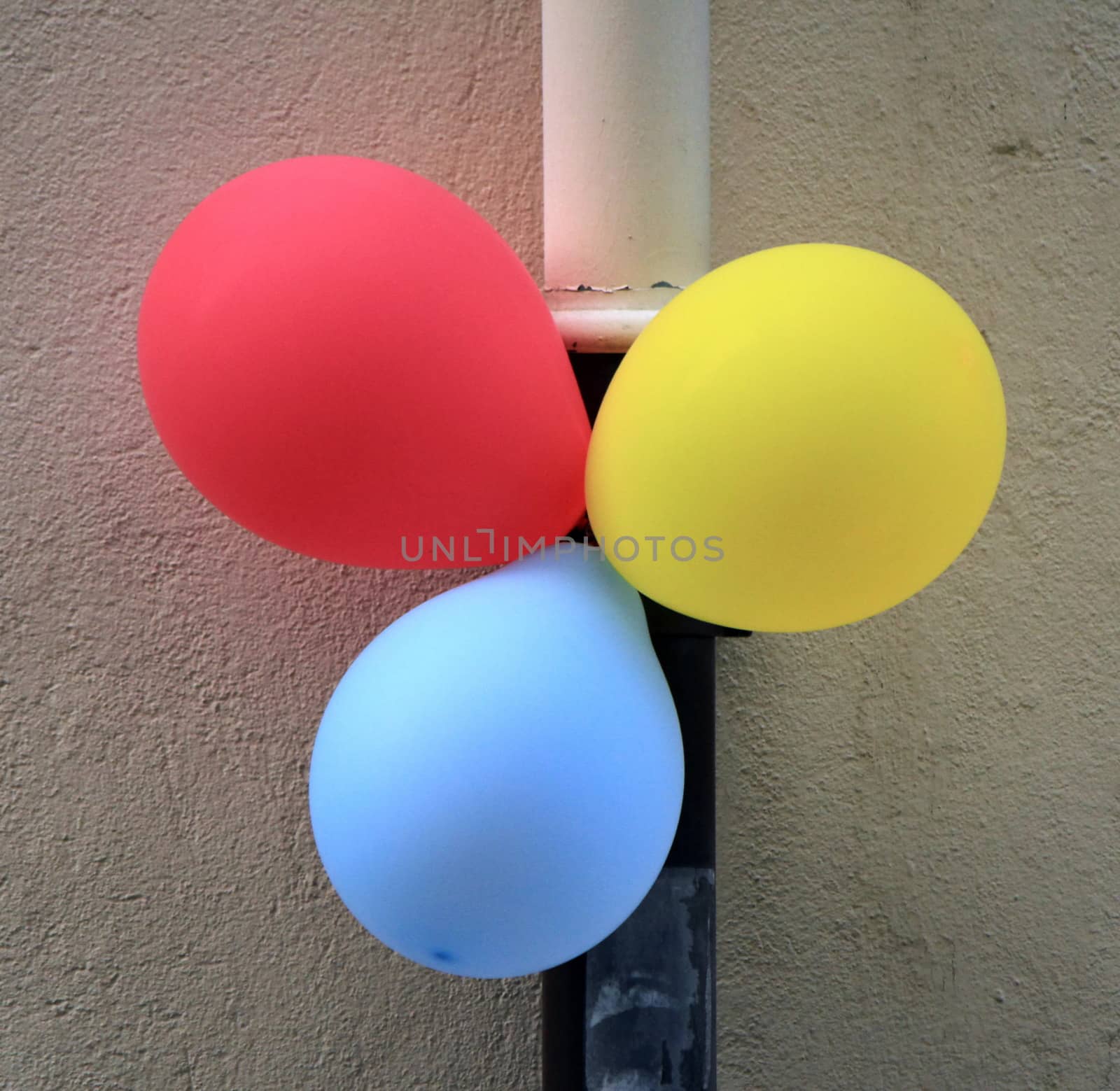Three colorful ballons attached in the street