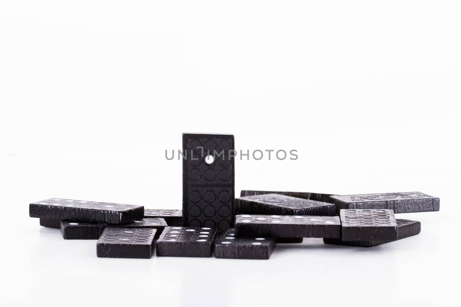 Leadership concept, domino standing out from the crowd, isolated on white background.