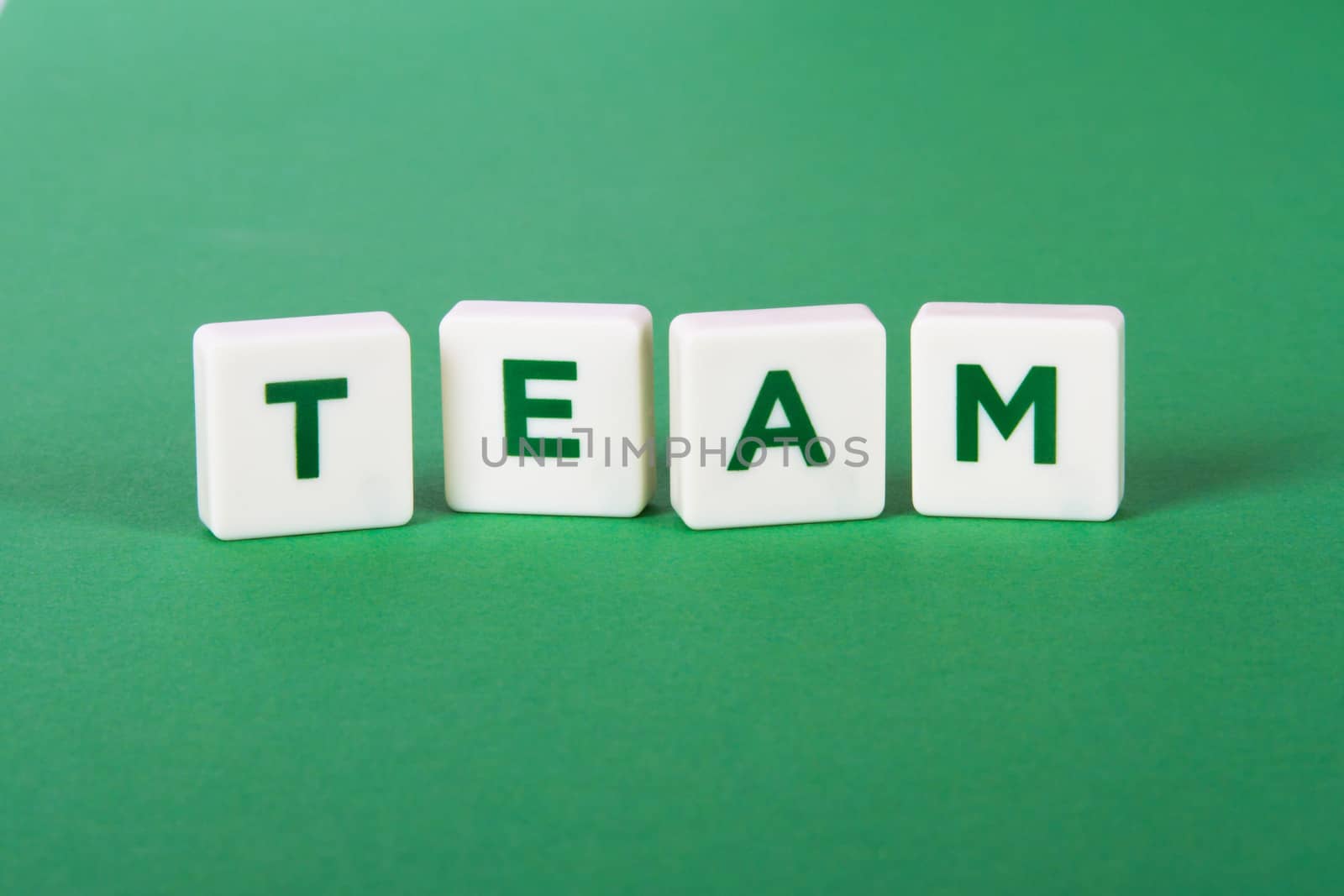 Team word in letters on green background.
