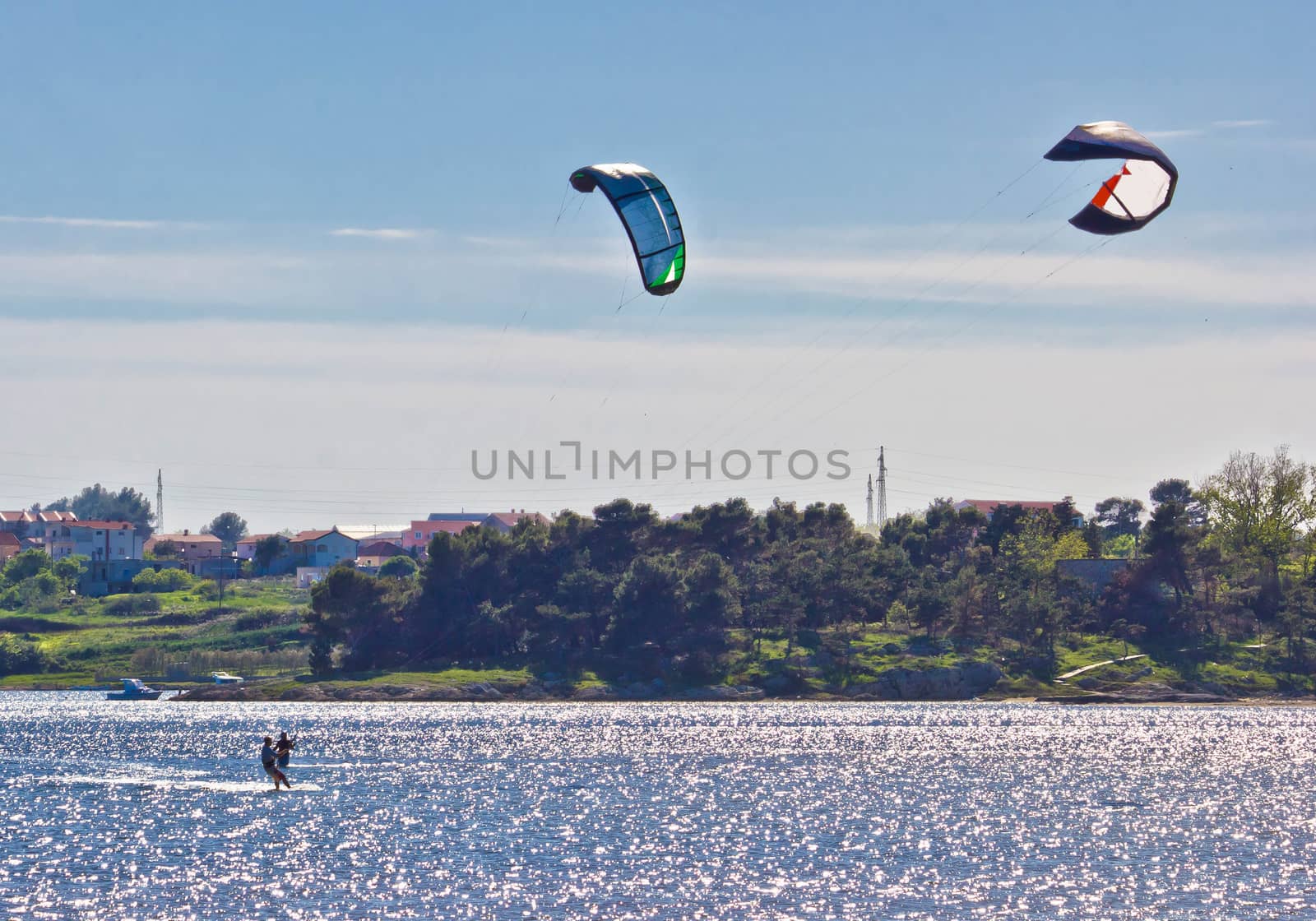 Pair of kitesurfers kitesurfing on the sea