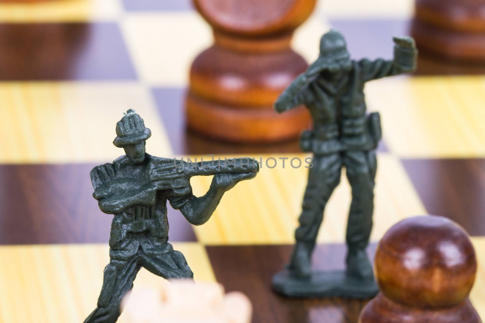 Miniature toy soldier on chess board.