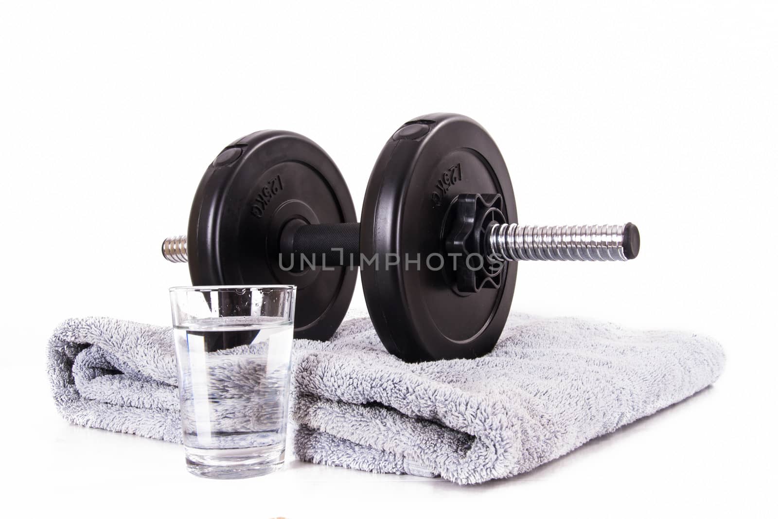 Black gym barbell, dumbbell with disks, blue towel and glass of water, isolated on white background.