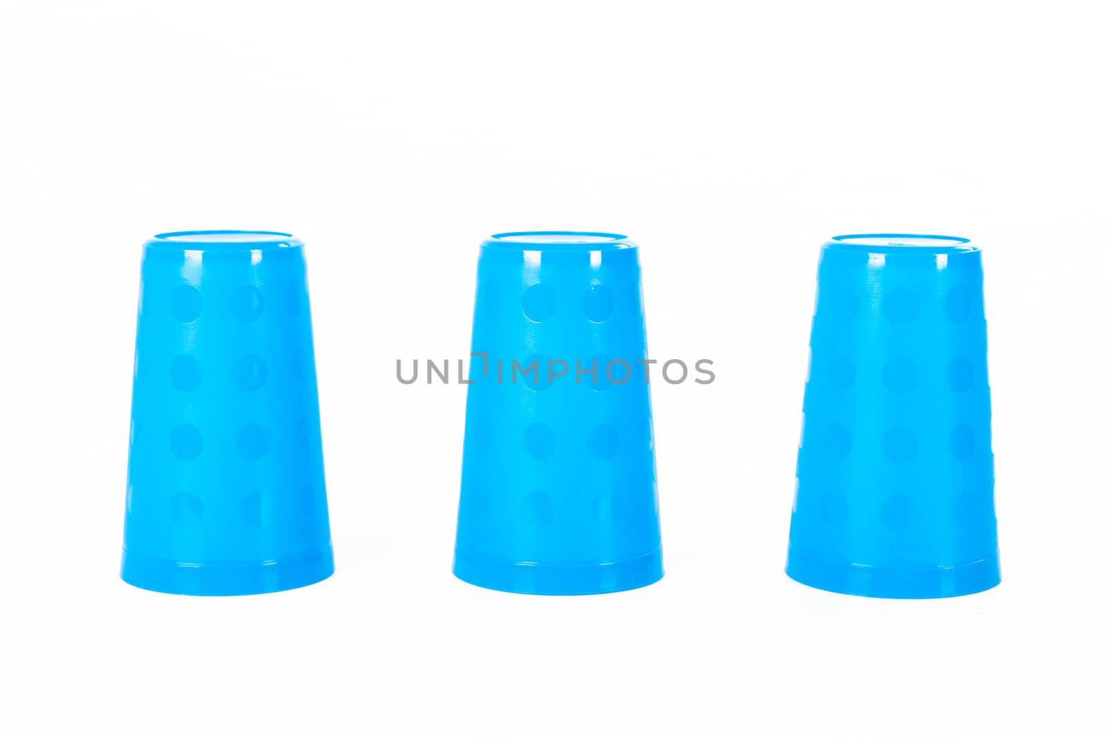 Thimblerig with three plastic glasses, isolated on white background.