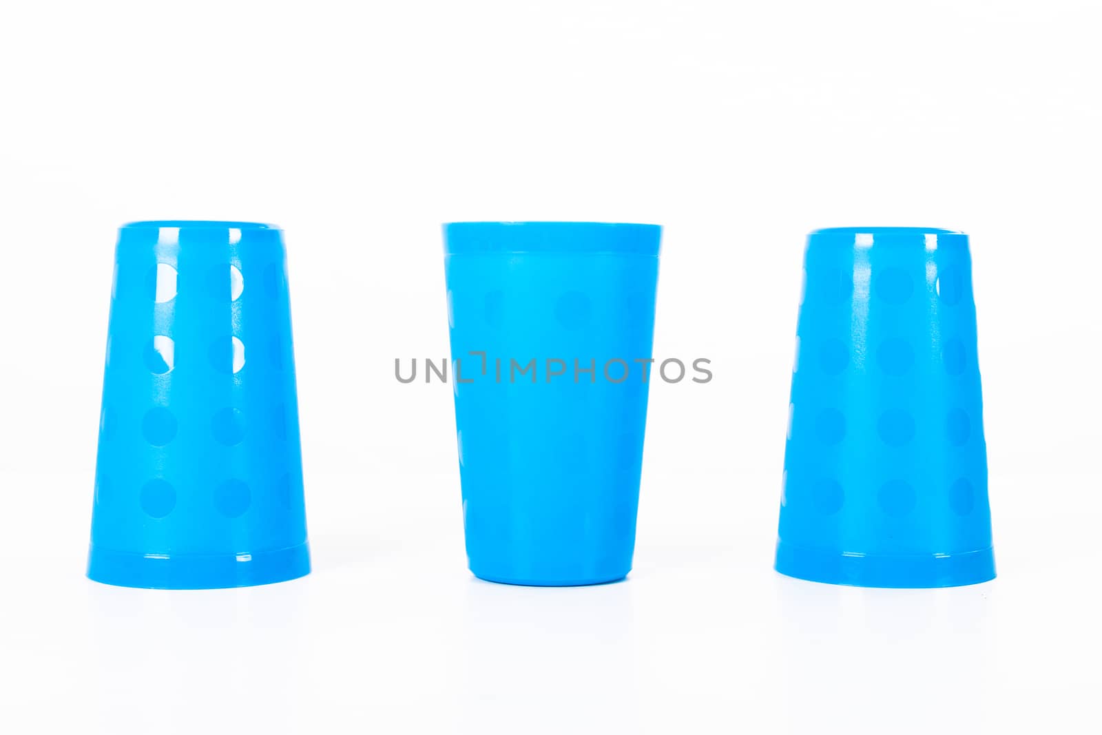 Thimblerig with three plastic glasses, isolated on white background.
