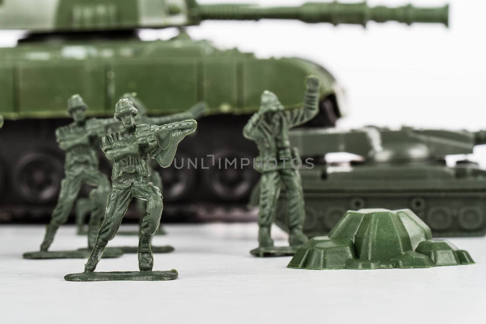 Miniature toy soldiers and tank, isolated on white background.