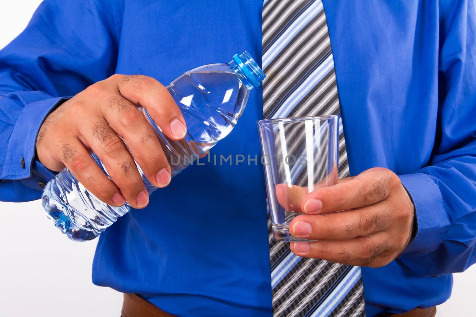 Water pouring into glass from plastic bottle by businessman.