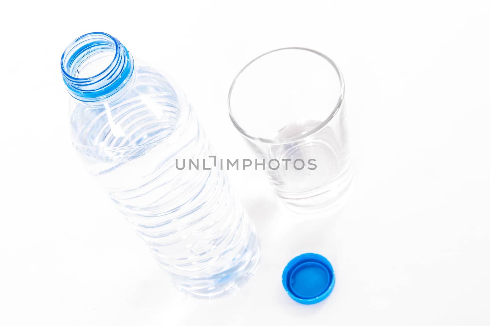 Plastic water bottle and glass, isolated on white background.