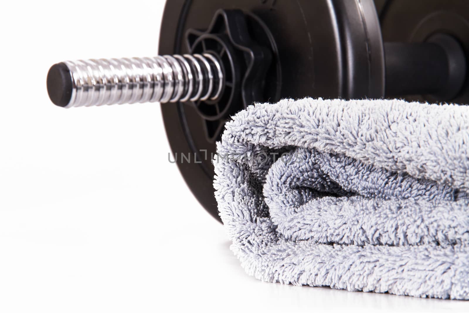 Black gym barbell, dumbbell with disks and blue towel, isolated on white background.