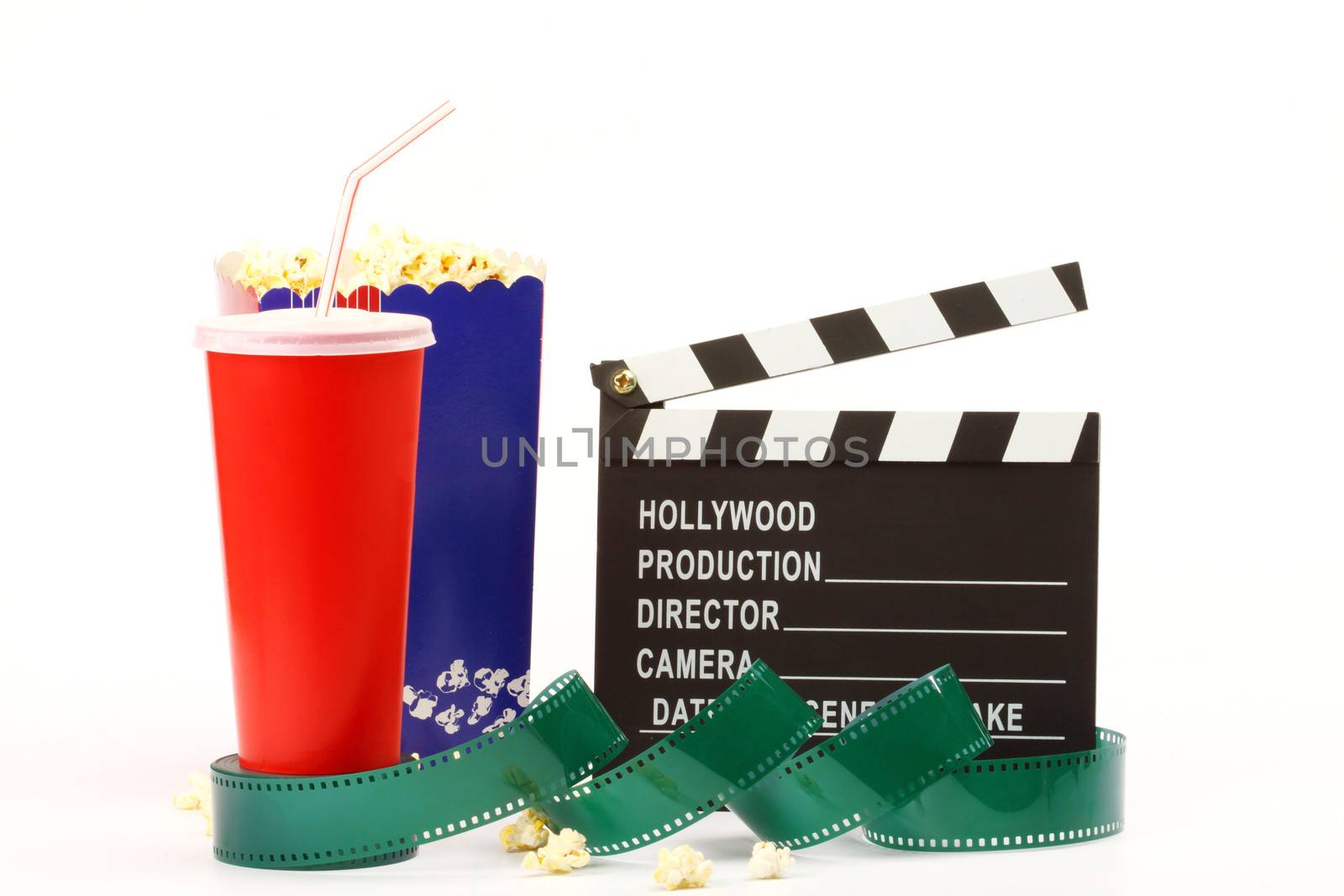 Movie clapper board, popkorn, soda pop and film roll over white 