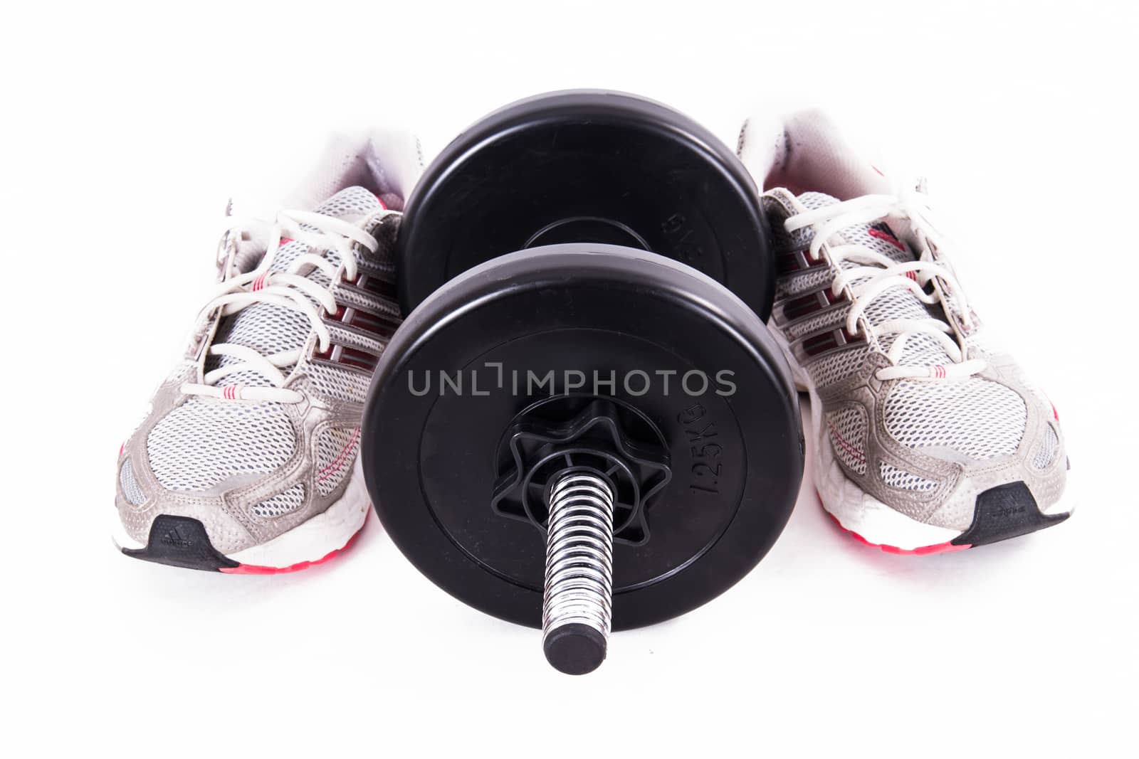 Black gym barbell, dumbbell with disks and sport shoes, isolated on white background.