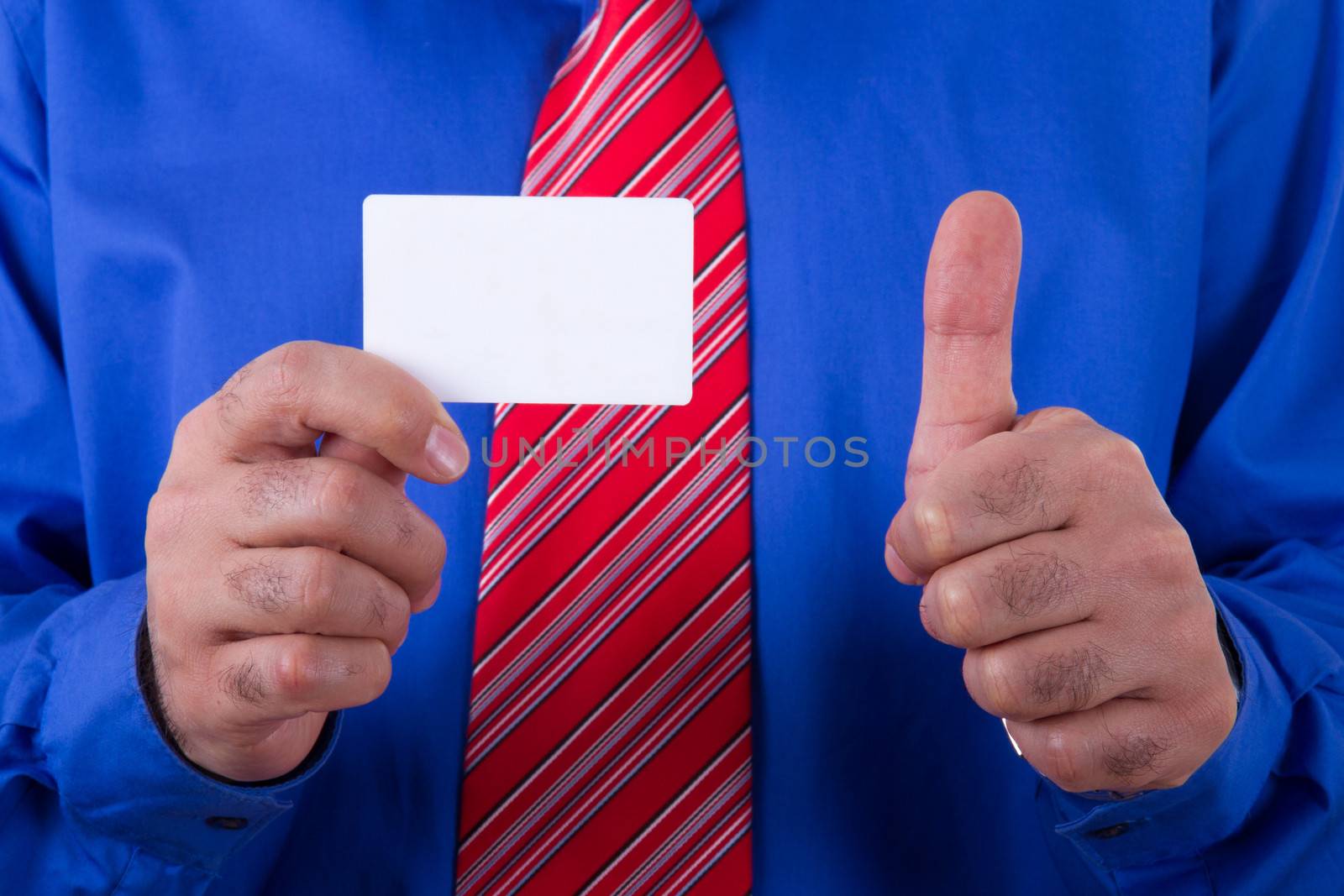 Businessman with red tie and blue shirt holding and showing blank, empty, white business card with approval, yes sign.