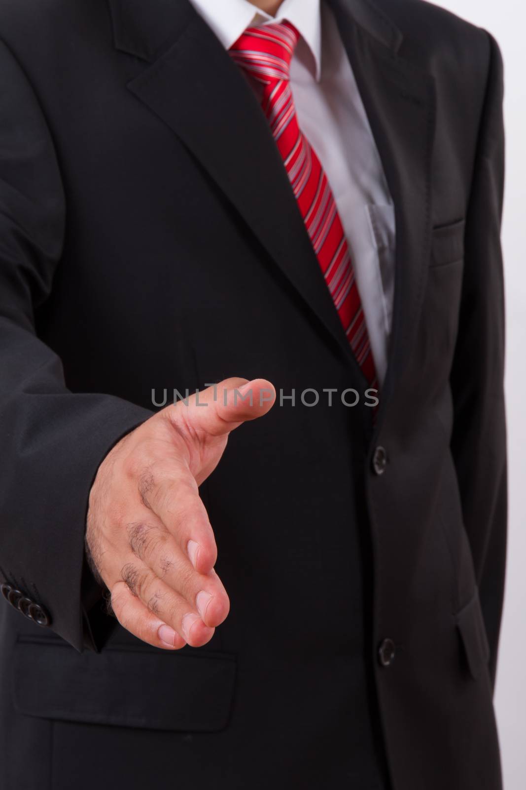 Businessman in suit extending hand to shake.