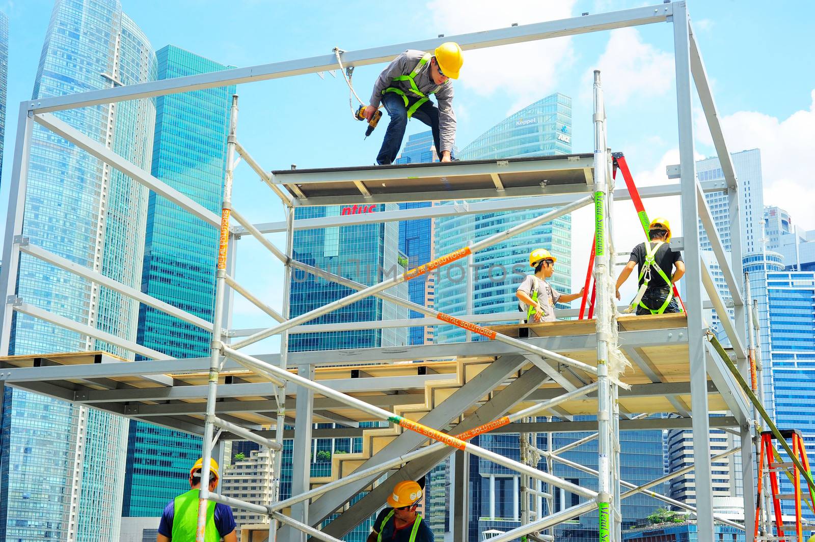 Singapore, Republic of Singapore -  May 09, 2013: Workers at construction site in front of Singapore downtown on in Singapore. Construction industry is expected to pull in some S$30 billion this year