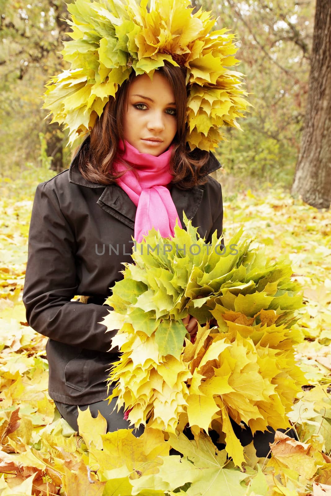 beautiful woman weaves a wreath of leaves