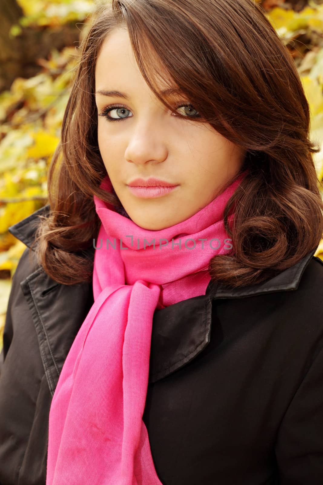 Portrait of a beautiful young woman in autumn park