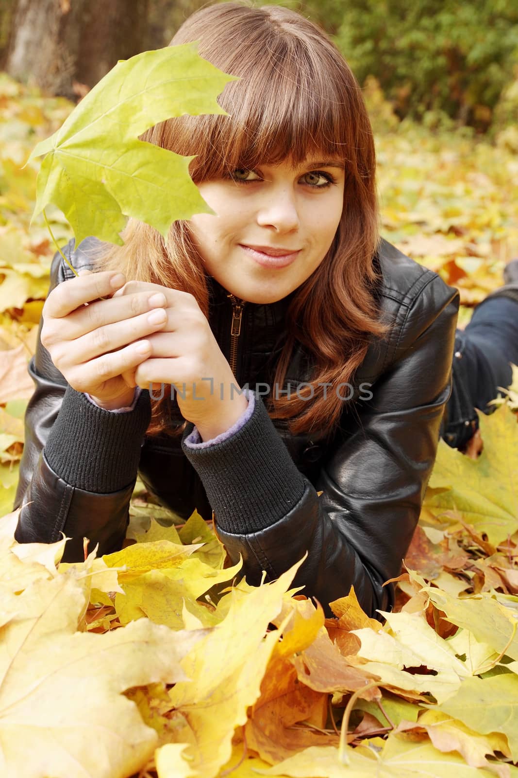 portrait of a girl lying on autumn leaves