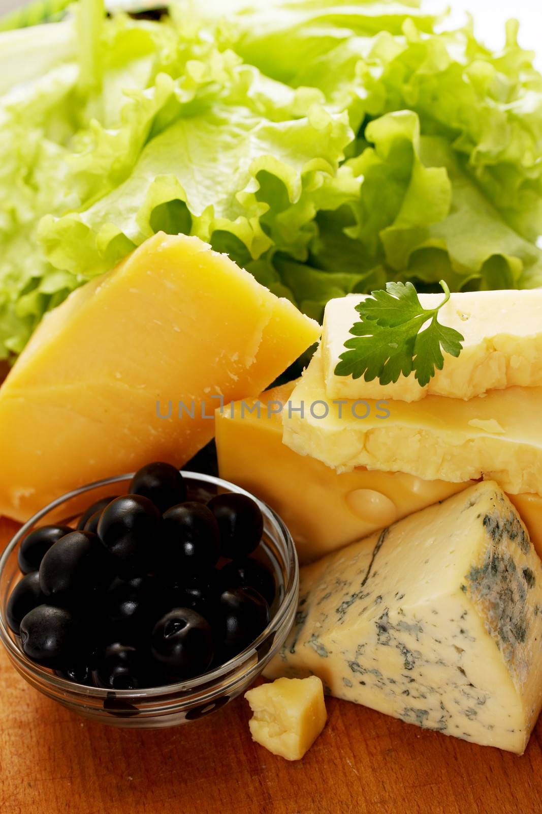 Still life of different types of cheese with olives