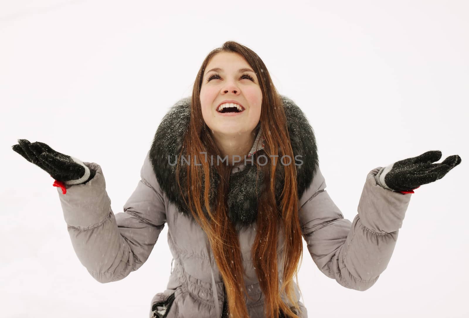  A young woman catches snowflakes in hand