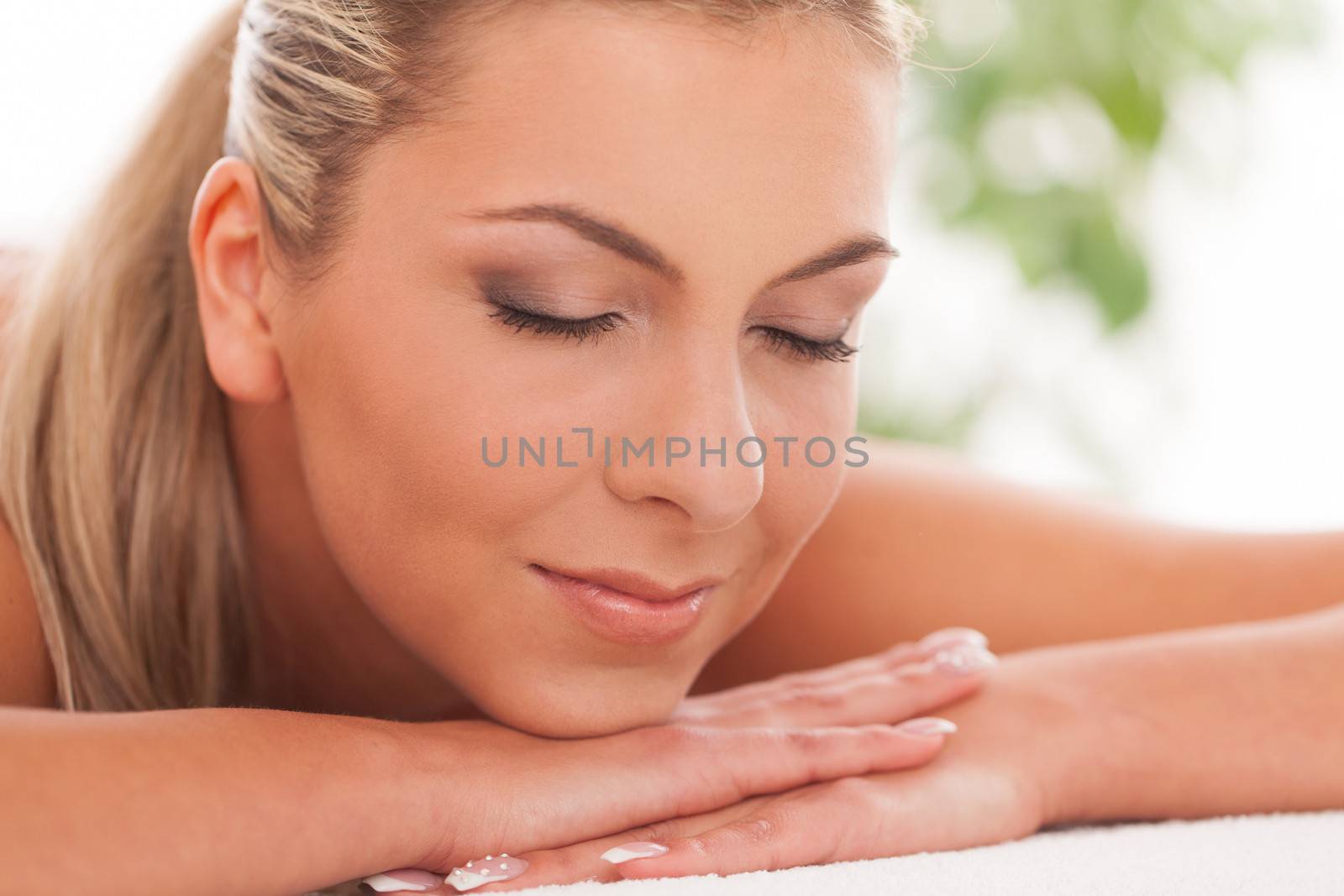 Beautiful caucasian woman with blond hair lying in a spa