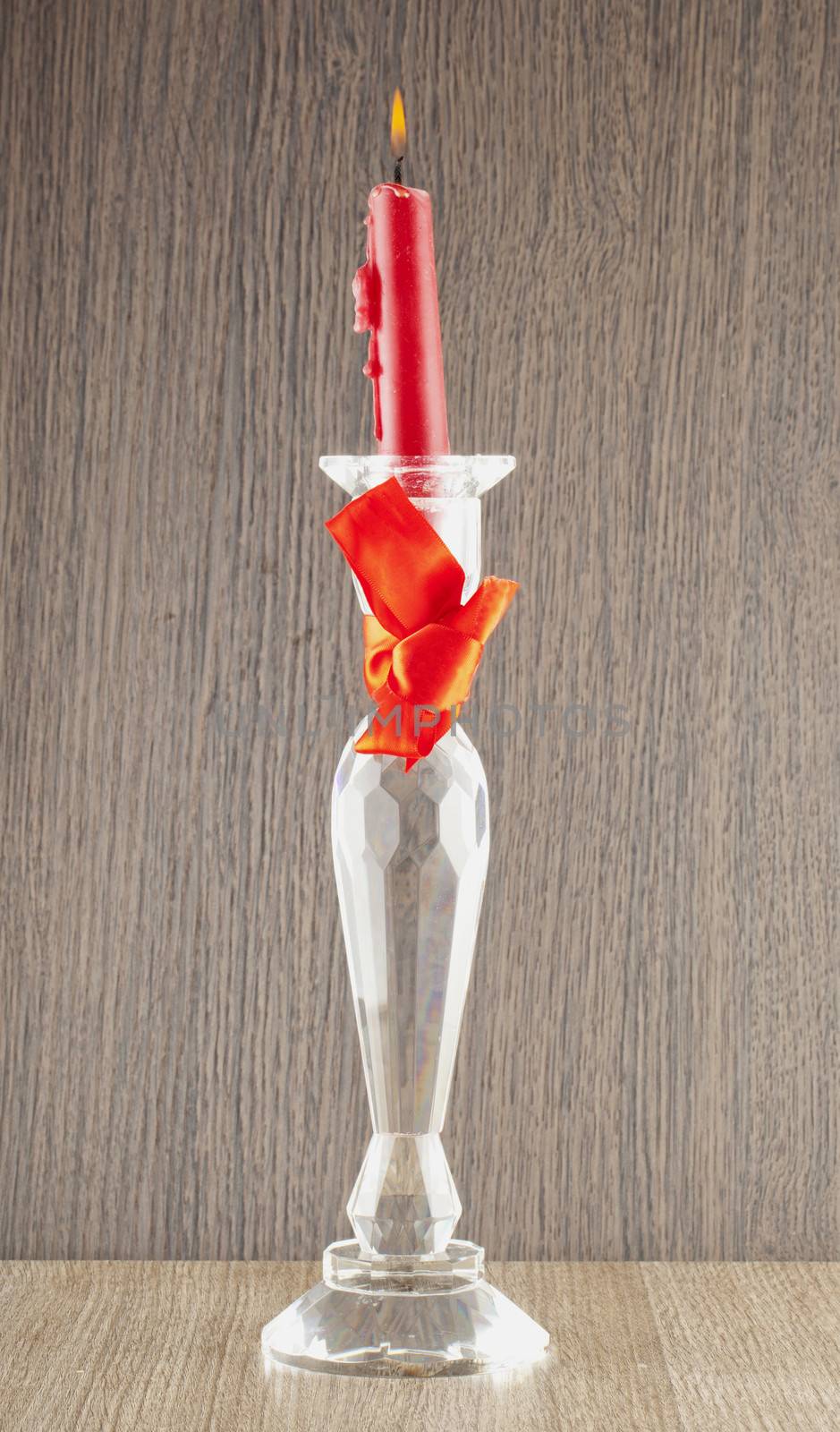 Red candle over an elegant glass candlestick