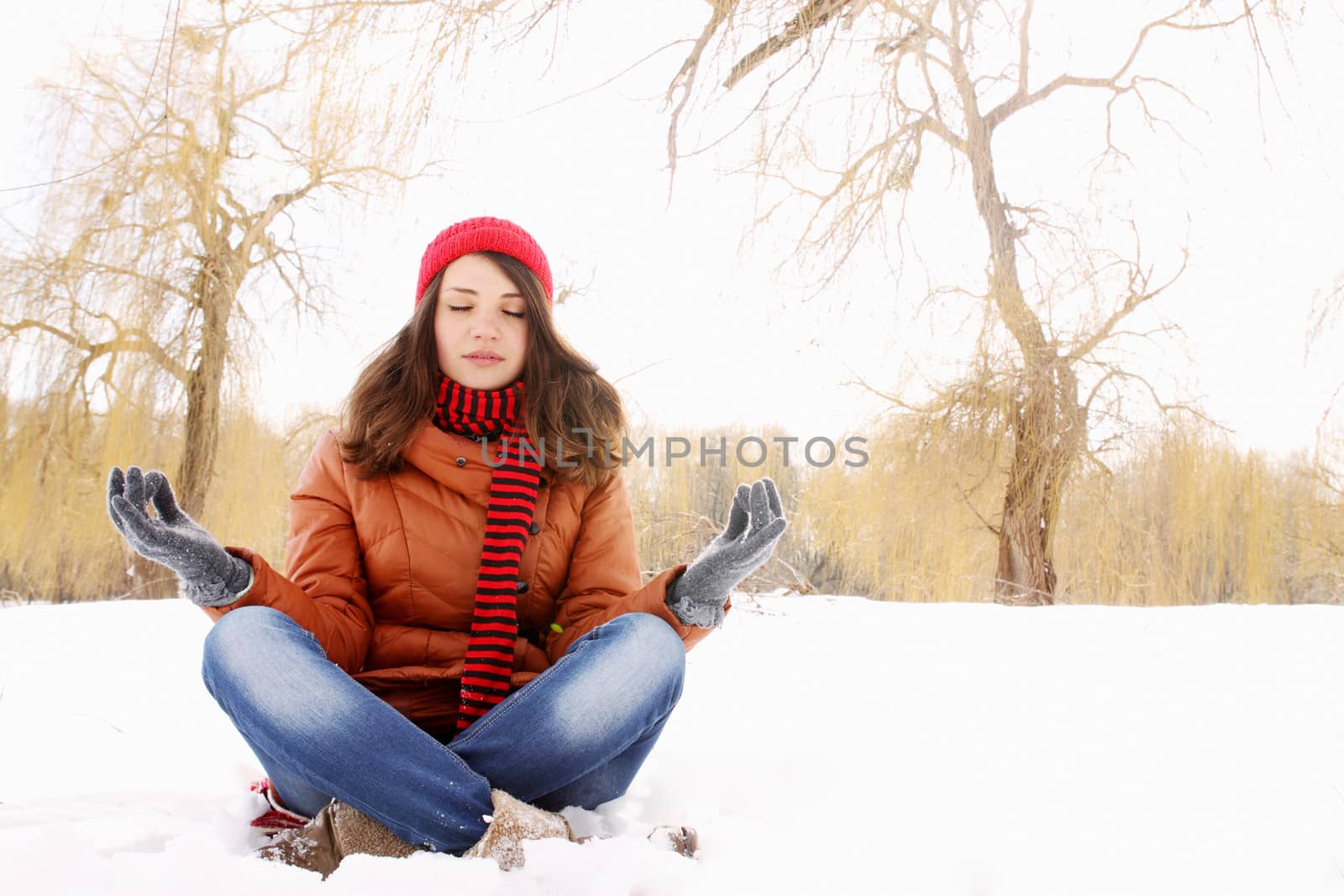 Young girl in lotus pose in the snow