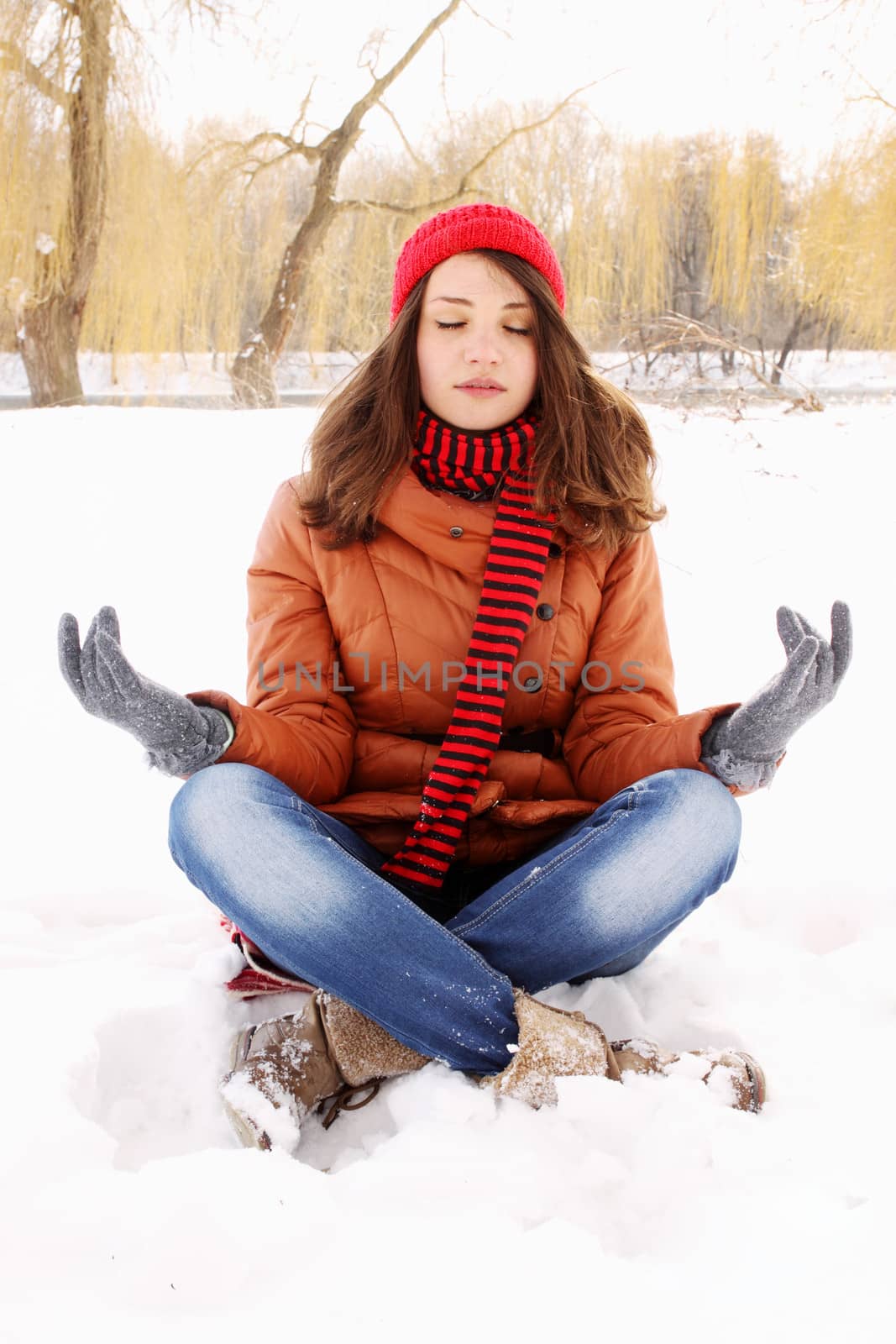 young woman in a lotus position on the snow