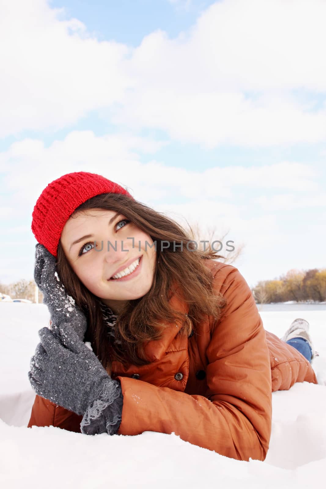 Beautiful young woman lying in the snow