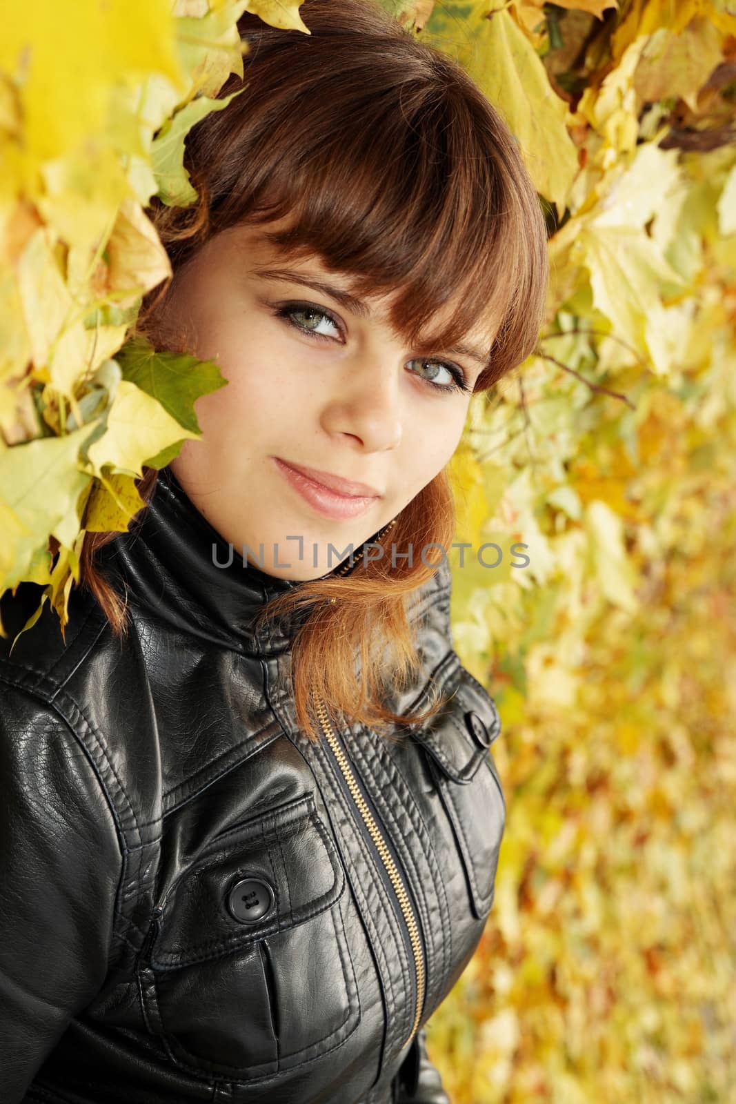 Portrait of a beautiful young woman in autumn park