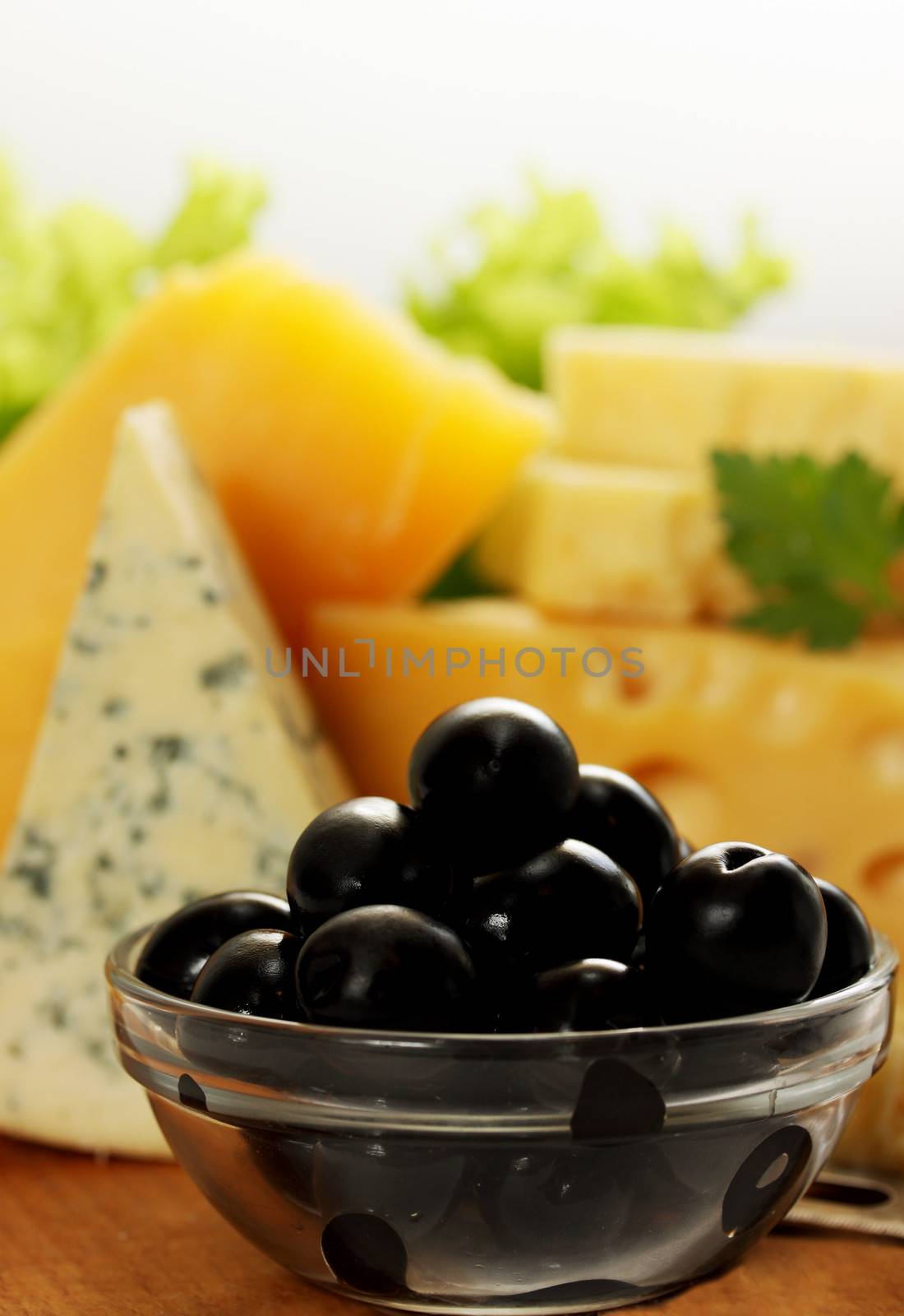 Still life of different types of cheese with olives