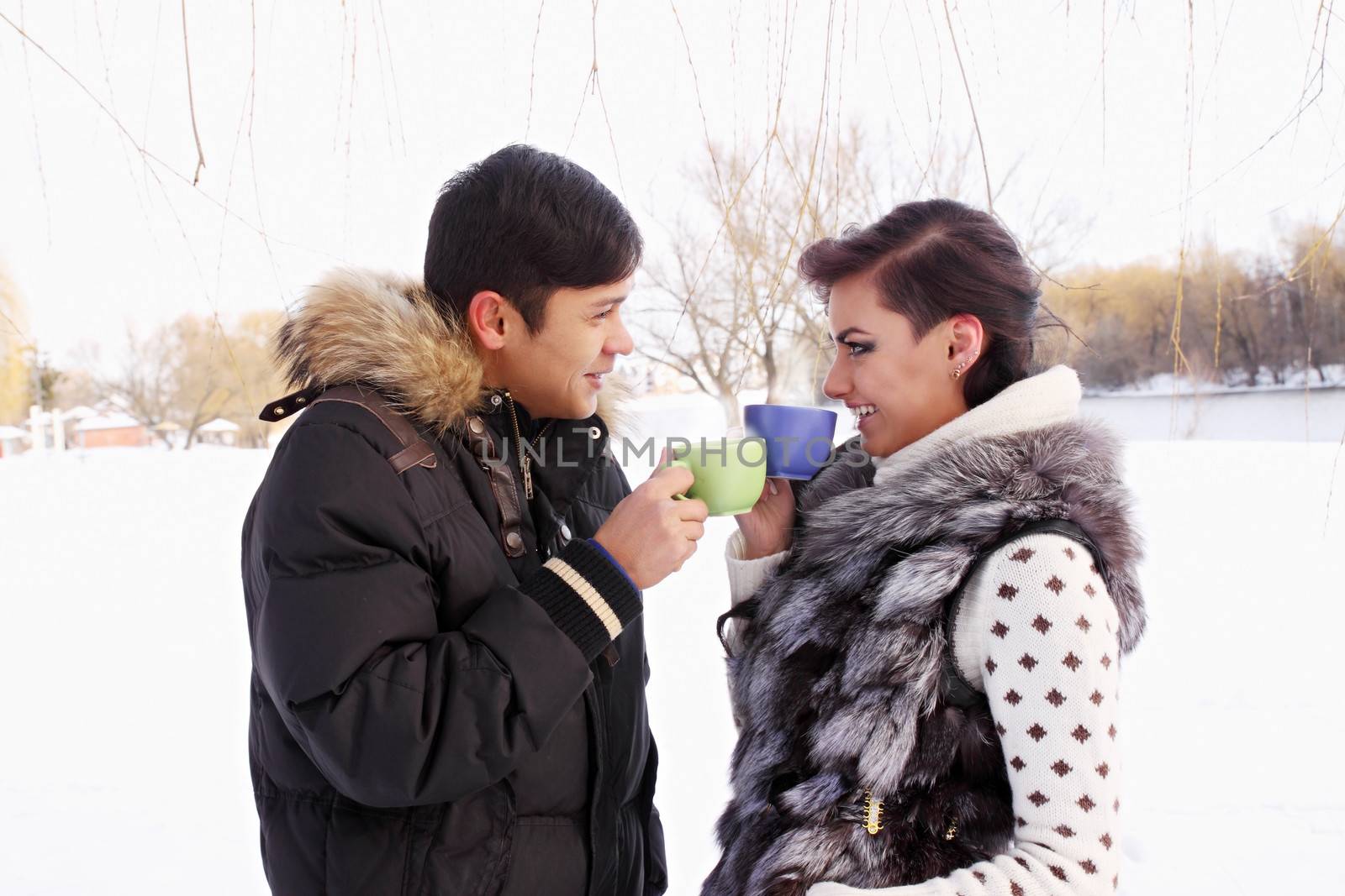 Young couple with a hot drink in winter outdoors