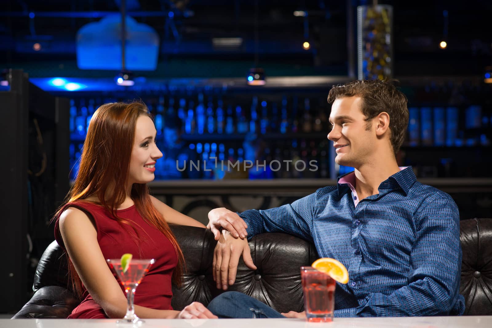 Young couple talking in a nightclub, have fun