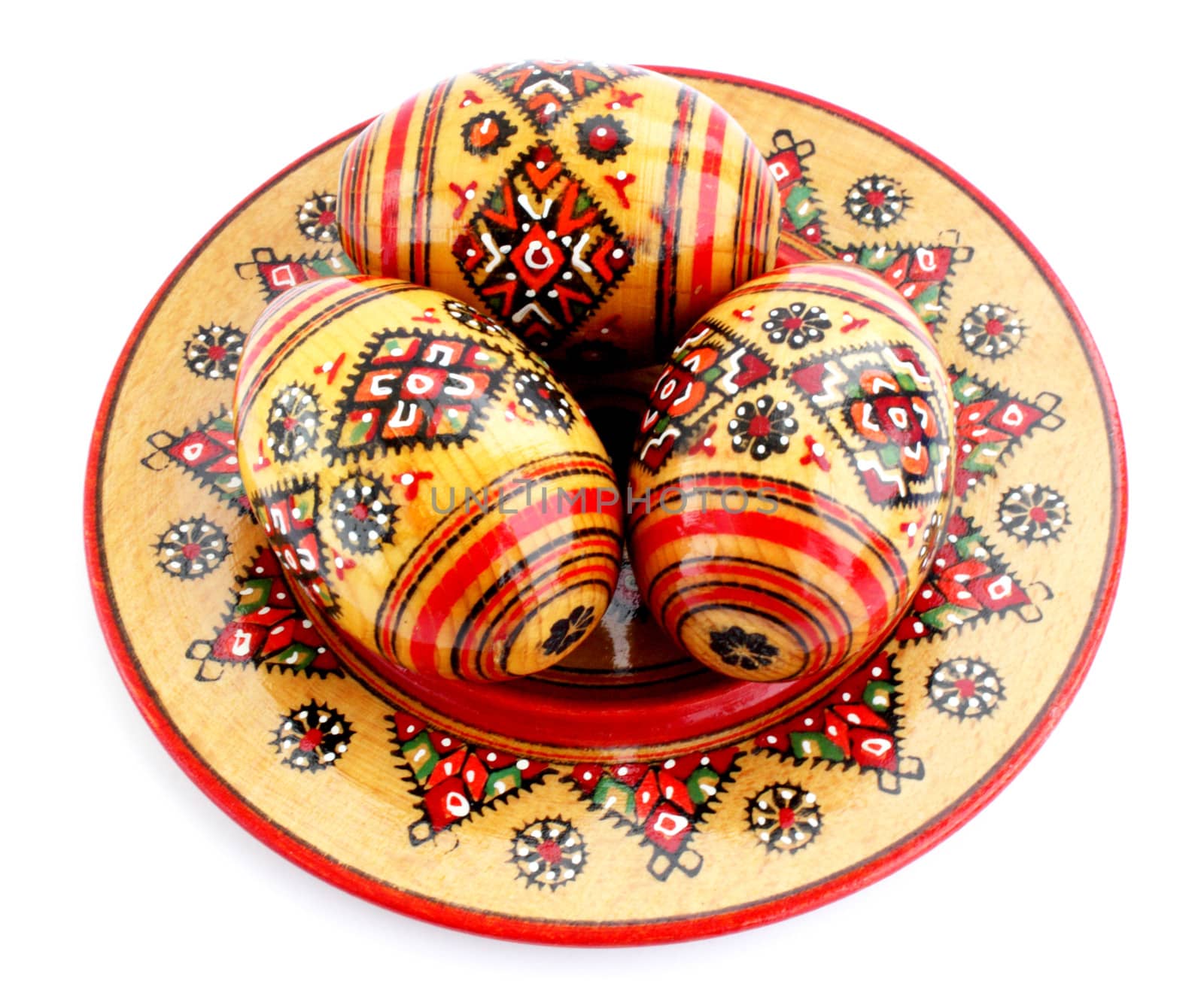 Three wooden eggs on the plate with the manual painting